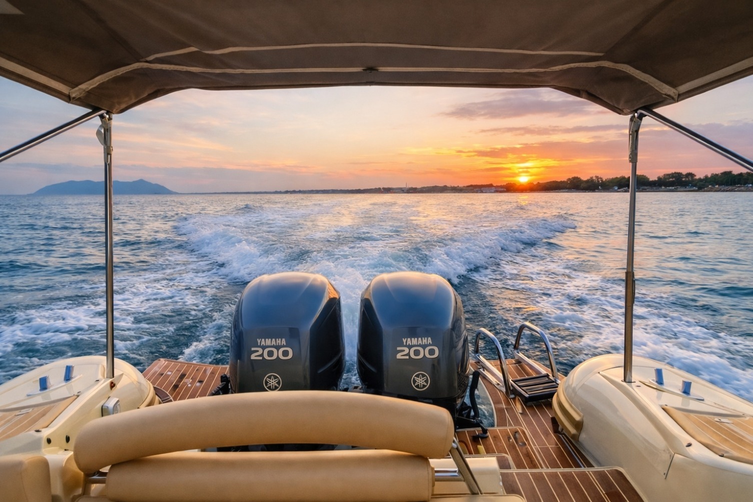 Vista posteriore di un gommone in navigazione al tramonto, con due motori Yamaha 200 e scia sull’acqua, mentre il sole cala dietro l’orizzonte e illumina il mare con tonalità arancioni e rosa.